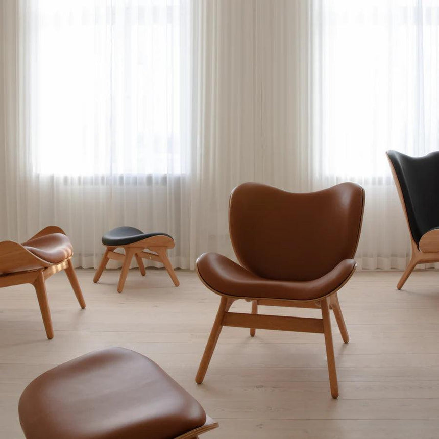 The Conversation Piece leather footstool with natural frame