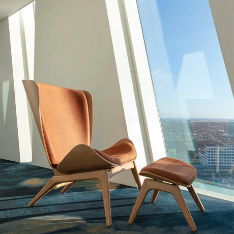 The Conversation Piece leather armchair with natural frame